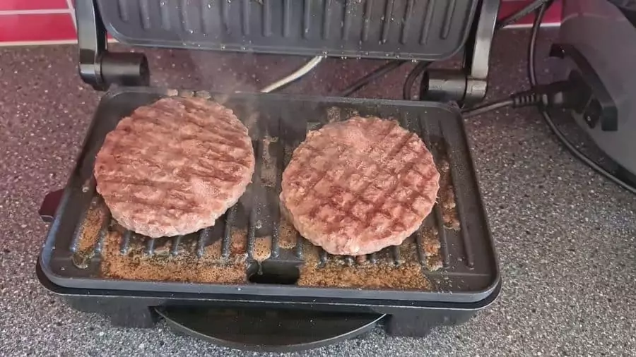 hamburguer clássico sendo feito em uma sanduicheira